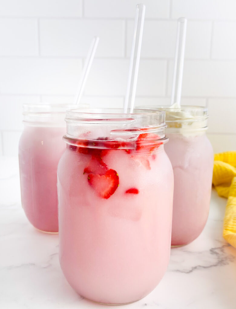 three drinks with pink juice inside each on a white countertop
