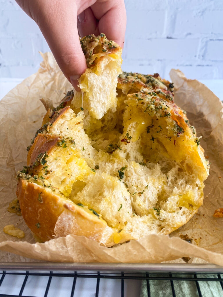 child's hand pulling bread from cookie sheet to eat