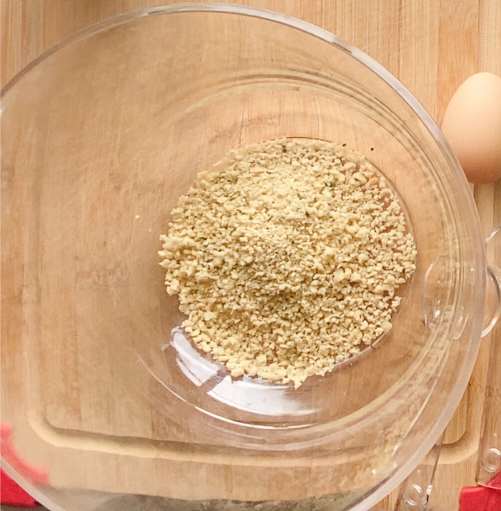 breadcrumbs in a bowl on a cutting board
