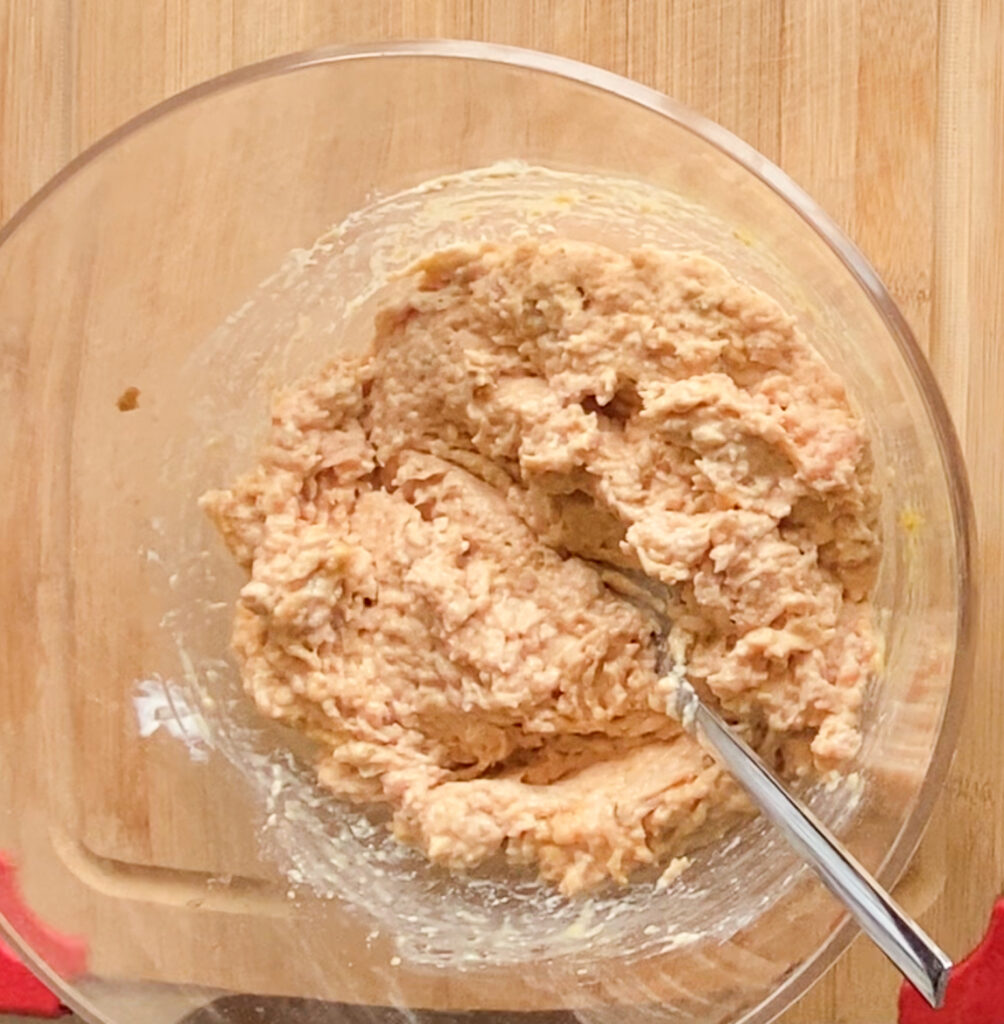 ground chicken mixture in a bowl on top of a cutting board