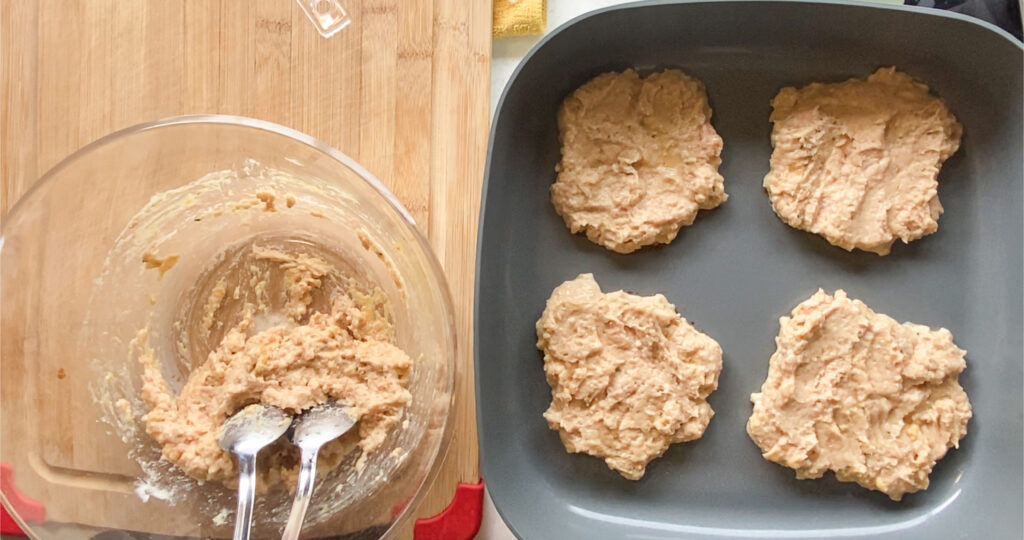 uncooked chicken burger patties in a skillet