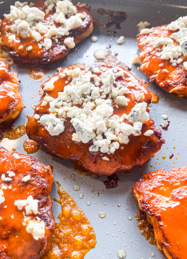 buffalo chicken burgers in a skillet topped with blue cheese