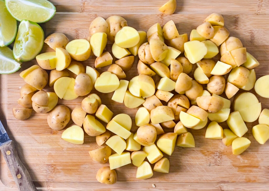 quartered potatoes on a cutting board 