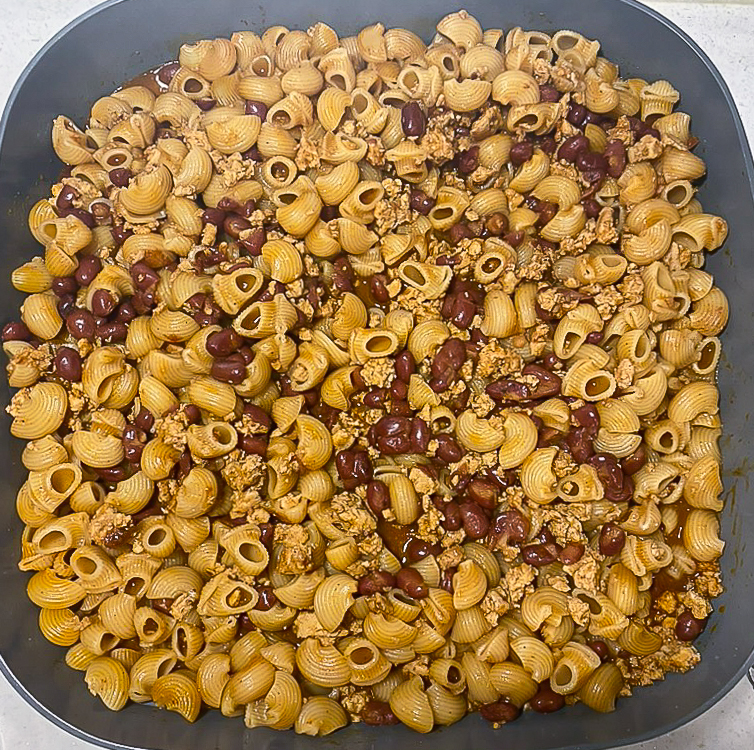 macaroni on top of beans in the skillet
