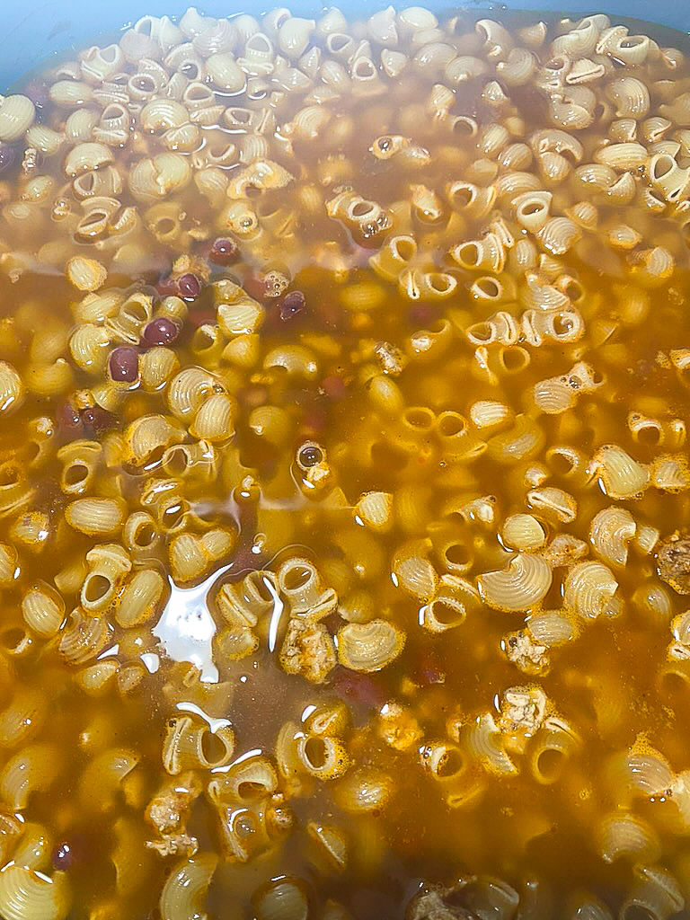 macaroni on top of beans in the skillet