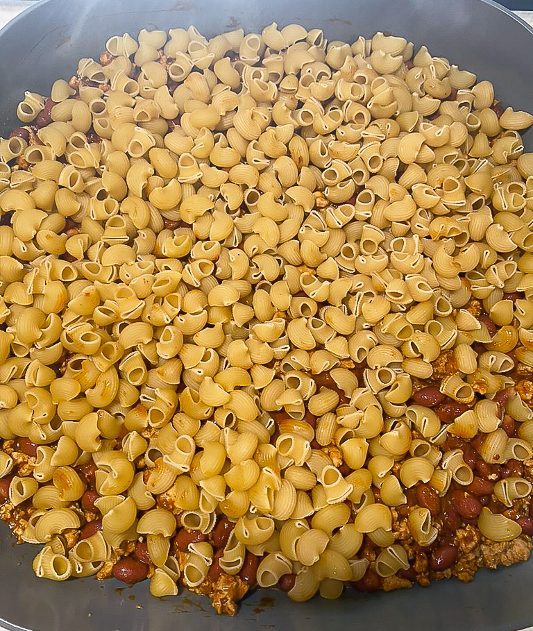 macaroni on top of beans in the skillet
