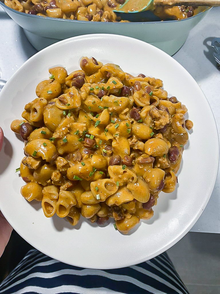 woman hold white plate with chili mac on top