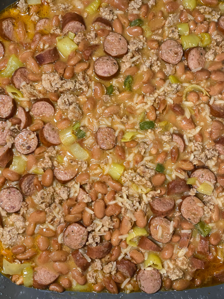 cajun pintos with rice and sausage and ground meat in a skillet