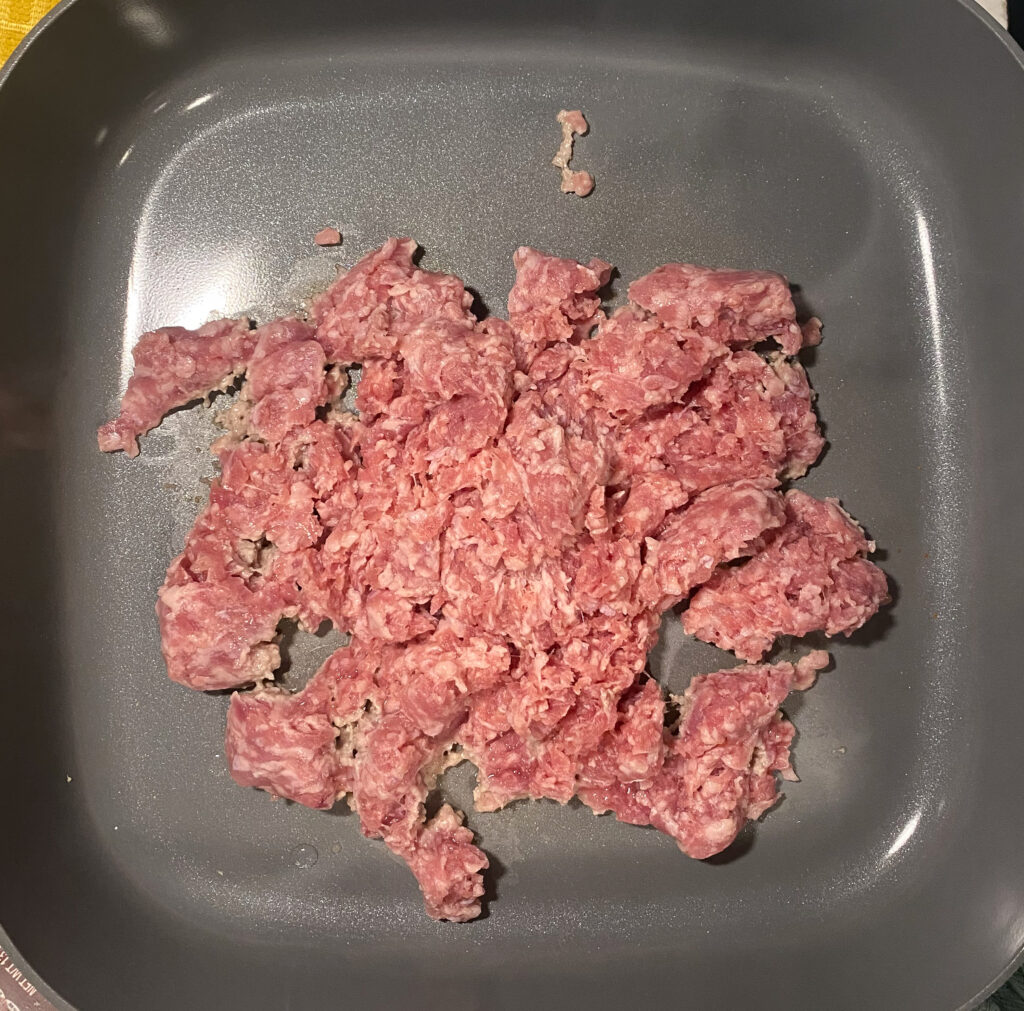 raw ground pork in a skillet