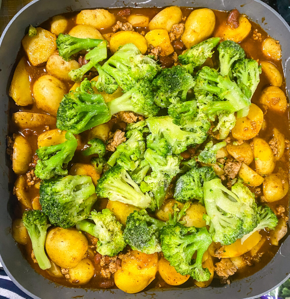 fully loaded baked potato skillet completely cooked in the skillet and topped with frozen broccoli