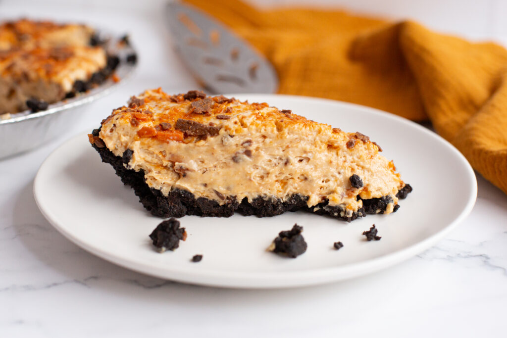 a slice of no bake butterfinger pie on a white plate