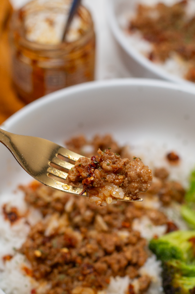 asian ground pork and rice on a gold fork