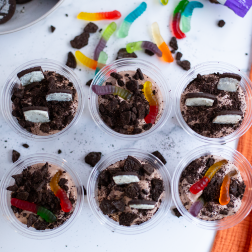 dirt and worm pudding cups placed on a bight counter