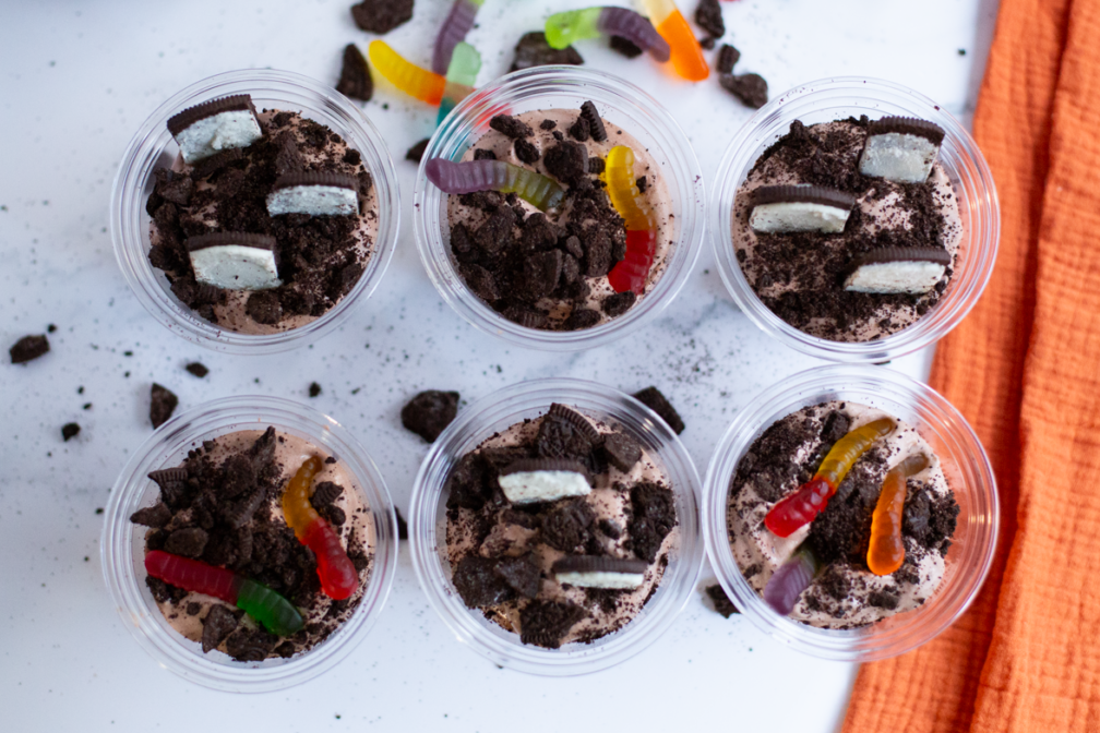dirt and worm pudding cups placed on a bright countertop