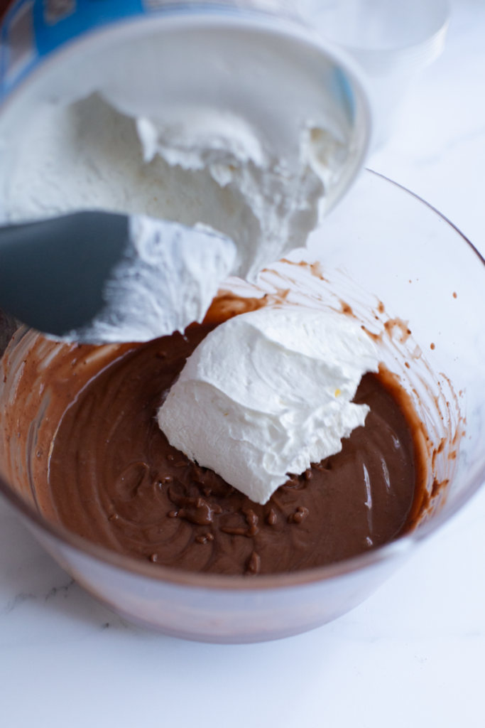 pudding and cool whip in a clear bowl on a counter