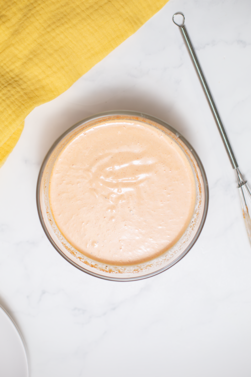 a bowl of burger sauce on a white counter