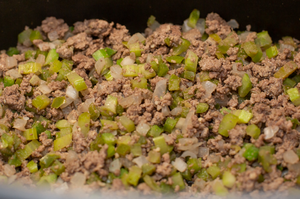 cook browned ground beef with onions, bell peppers, and celery in a pot