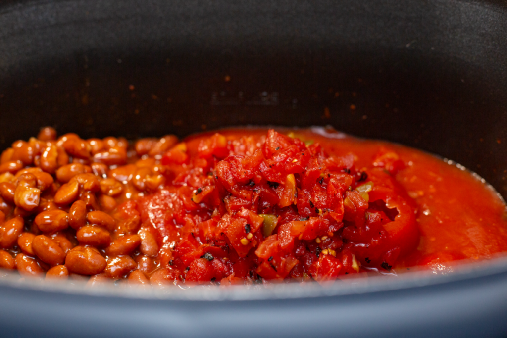 brown ground beef with chili beans and tomato sauce and rotel on top