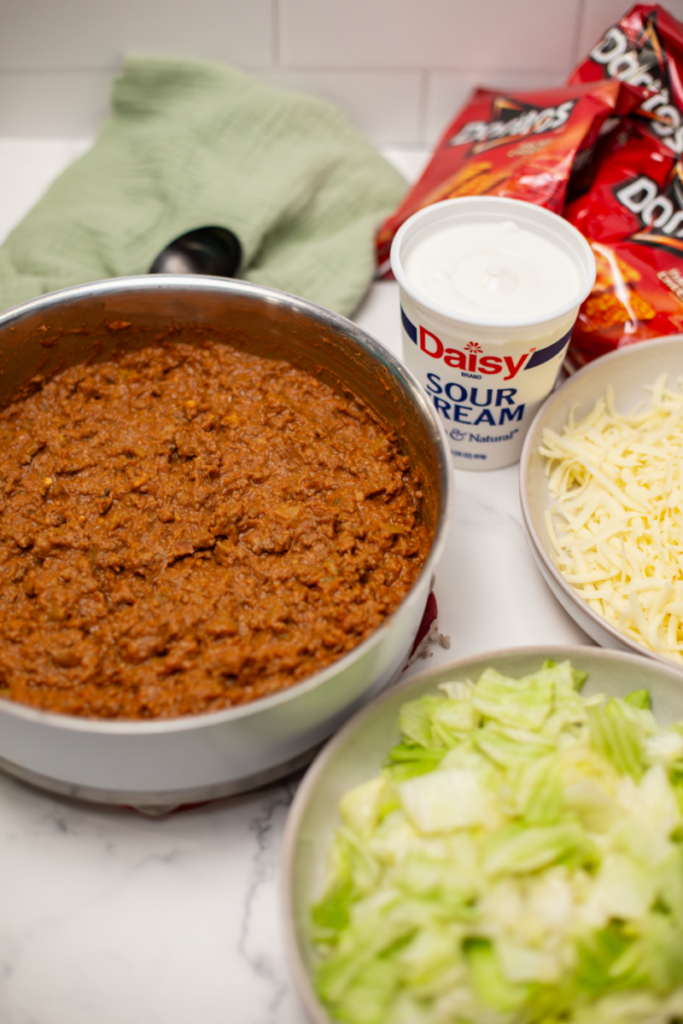 taco meat and walking taco toppings on a white counter