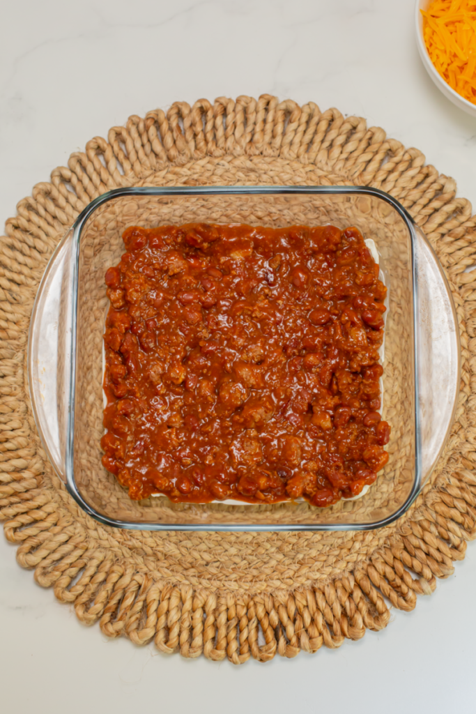canned chili into the bottom of a glass casserole dish