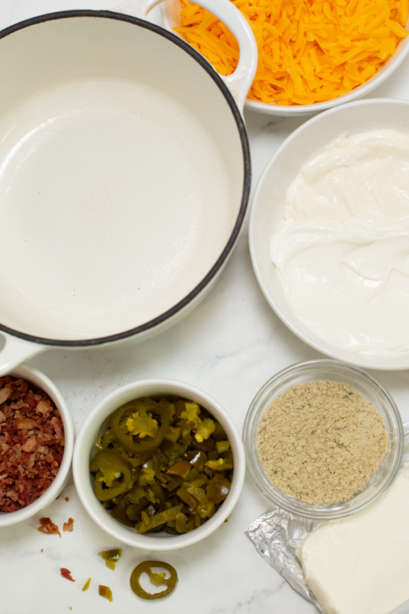 creamy cheddar jalapeno bacon ranch dip on a white surface