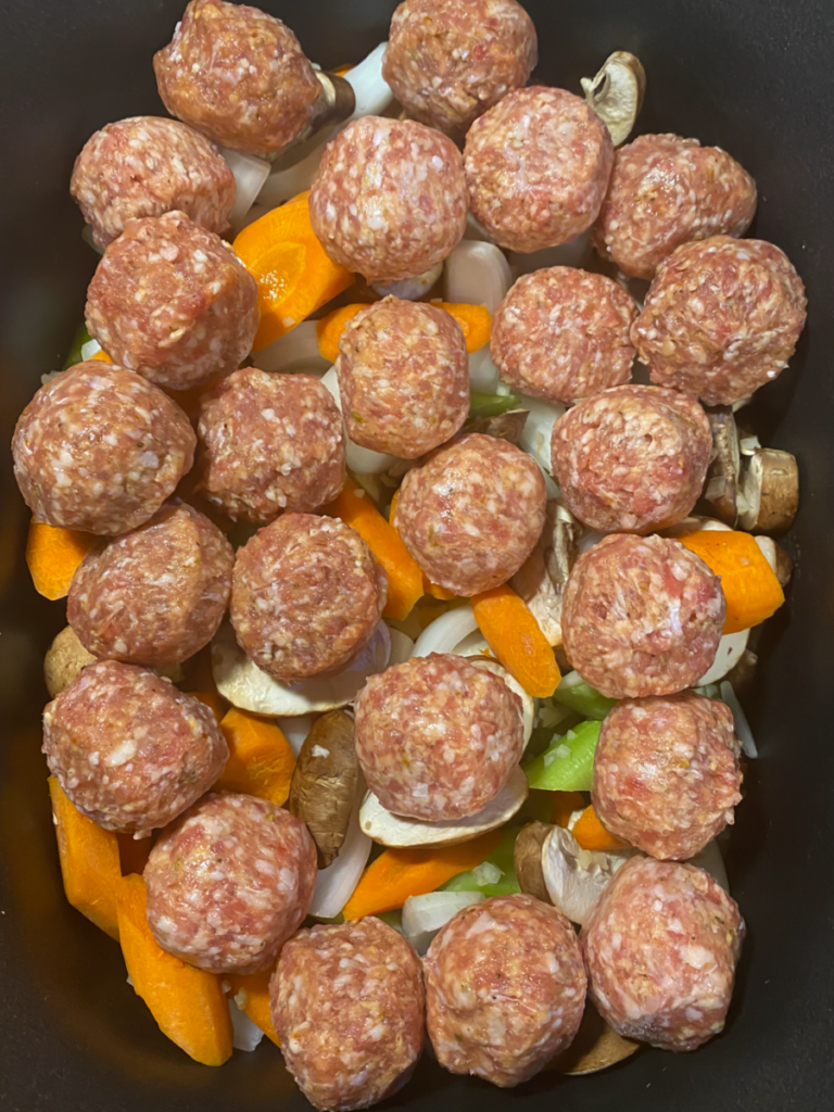 meatballs on top of the vegetables in the slow cooker. 